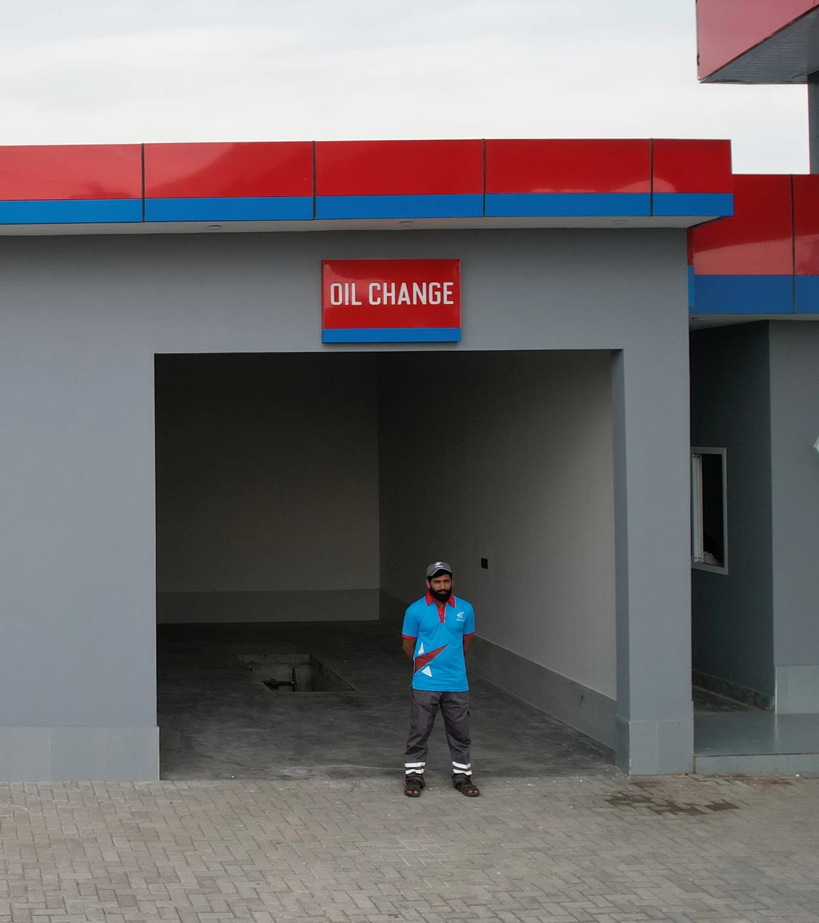 Benzin Oil Change service bay with an attendant outside.